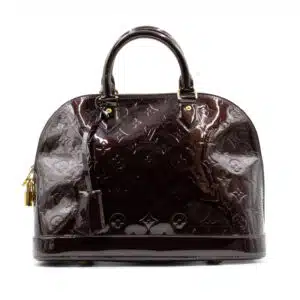 Dark brown patent leather handbag with top handles and monogram embossed pattern.