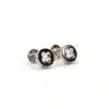 A pair of silver cufflinks with black and white four-leaf clover designs.